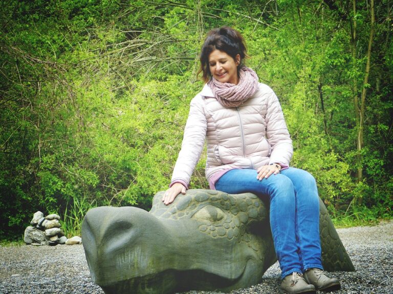 Scultura colorata nel Giardino dei Tarocchi, parco artistico in Toscana, con visitatori in esplorazione.