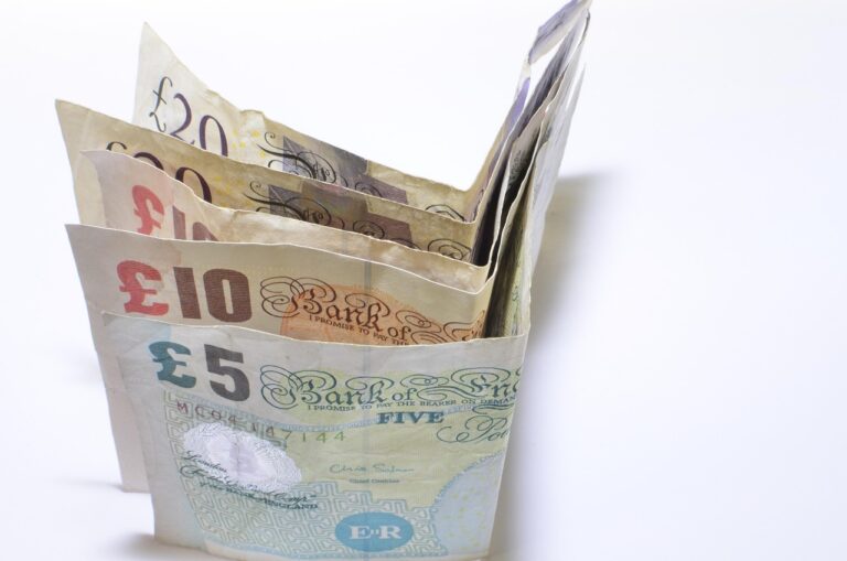 Due mani che dividono monete su un tavolo, simboleggiando la divisione di un conto cointestato.